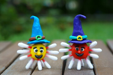 Virus figurines made of plasticine decorated with a festive hat. Ideas for Halloween. The symbol of the coronavirus.