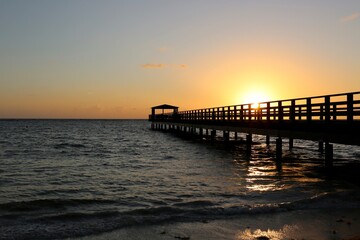 Fototapeta na wymiar Pier in the sunrise on the sea beach