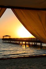 Pier in the sunrise on the sea beach