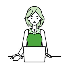 デスクで座ってPCを使っているドレスの女性