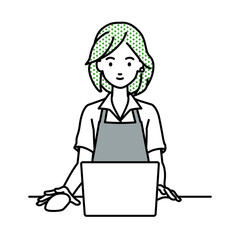 デスクで座ってPCを使っているカフェ店員の女性