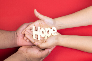 two hands holding word hope, acquired immunodeficiency syndrome, red background