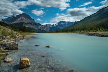  WATERS AND ROCKY BANKS OF SUNWAPTA RIVER WITH TANGLE RIDGE AND LONG PINE COVERED SLOPES IN...