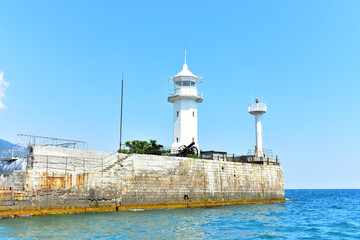 White lighthouse on the view of the sea, Crimea, Yalta, August 2021.