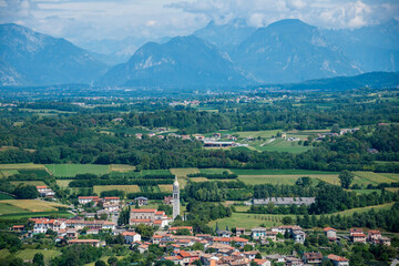 Fotografía aérea de un pueblo en la región italiana de Friuli-Venezia-Giulia, con las montañas de los Alpes de fondo