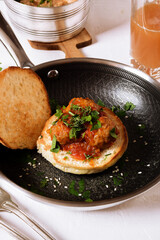 Homemade food. Meatballs in tomato sauce on a homemade bun in a hot frying pan. Freshly squeezed grape juice.