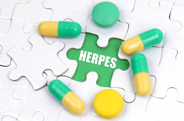 There are pills and vitamins on the white puzzles. Inside on a green background the inscription - HERPES