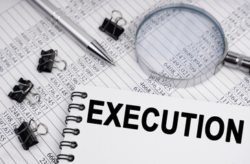 On the table is a magnifying glass, reports, a pen and a notebook with the inscription - EXECUTION