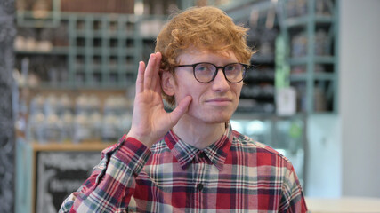 Portrait of Young Redhead Young Man Listening Carefully