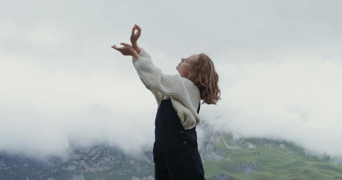 Russia, Caucasus. A woman stands on the parapet against the backdrop of hills