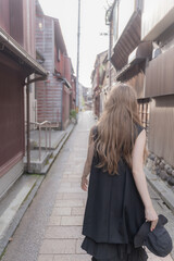 Fototapeta na wymiar 日本の昔ながらの街並みと歩く女性の後ろ姿