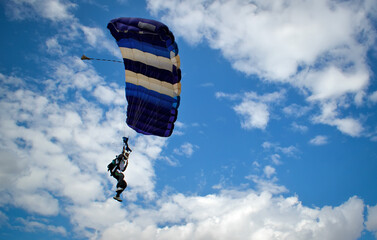 Skydiver preparing to land and touch the ground.