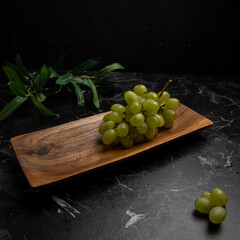 fresh green fruits in a wooden cheese board