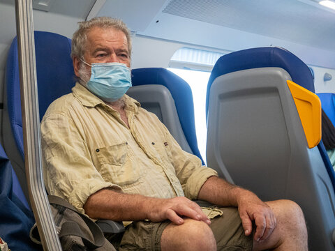 Senior man traveling on a bus with a face mask
