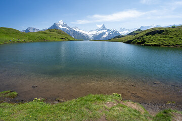 les bords d'un lac de montagne avec une chaine de montagne en fond