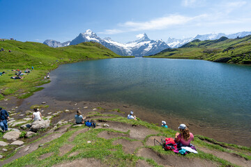 Fototapeta na wymiar des touristes qui mangent au bord d'un lac de montagne 
