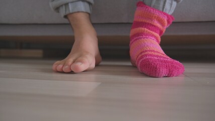 Bare Feet of Caucasian Male Waking Up in The Morning and Putting On Funny Warm Colorful Socks
