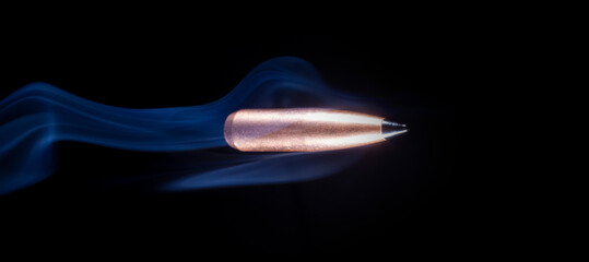 Speeding bullet with smoke behind on a black background - obrazy, fototapety, plakaty
