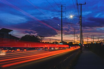 Paisaje urbano con el trafico en forma de haces de luces de fondo, tomada con larga exposición con destaques en azul, rojo y naranja 