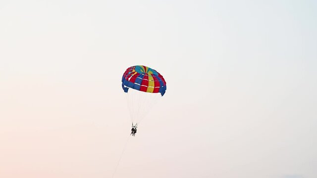 Parachute and boat on the sea at summer. Tourist having fun with parachute on the sky. Extreme sport and adventure. 