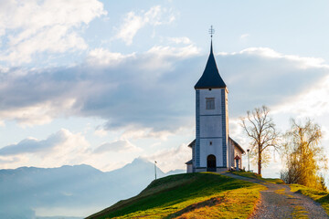 Fototapeta na wymiar On the hilltop the magnificent Church of St. Primus and St. Felician with beautiful views of the landscape, Jamnik village, Kranj village at sunrise, Triglav National Park