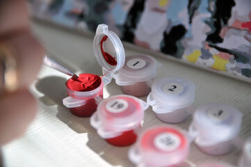 Painting by numbers. Jars of paints, brush, canvas.