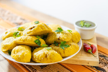 plate of colombian mempanadas on a wooden plank, typical, latin food, with aji sauce