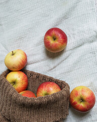 ripe fragrant apples scattered from the bag on a white background