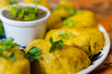 close up of a Colombian empanada dish with aji sauce