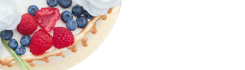 Close-up of a cake with raspberries and blueberries, juicy colors.