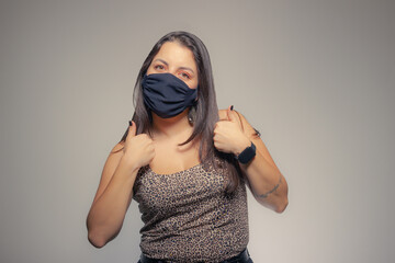 Young woman with a black mask on her face showing thumb up. 