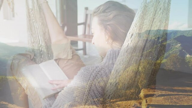 Composite of happy woman in hammock reading book, and sunlight on mountain countryside
