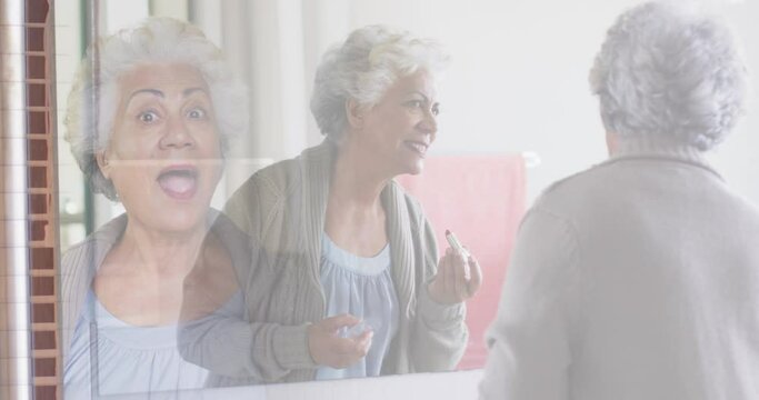 Composite Of Cheerful Senior Woman In Mirror Putting On Lipstick, And Greeting Visitor At Front Door