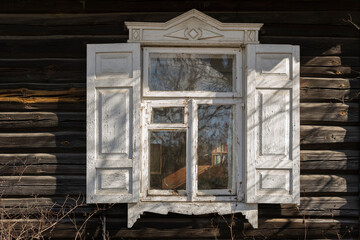 beautiful antique window in white frame on a wooden house