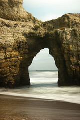 Oceanside rock arch in receding tide