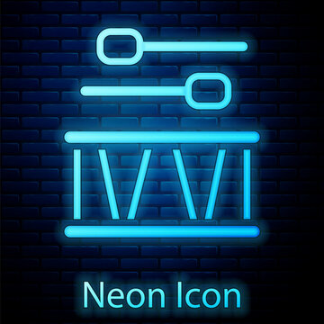 Glowing neon Drum with drum sticks icon isolated on brick wall background. Music sign. Musical instrument symbol. Vector