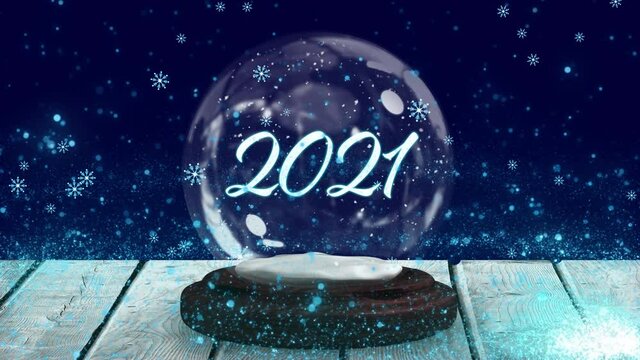 Animation of 2021 in snow globe on wooden boards, shooting star and snow falling