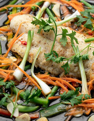 chinese style steamed fish fillet with vegetables on hot plate