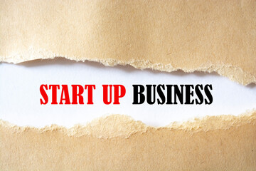 START UP BUSINESS written under torn paper on the white background