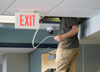 technician installing security camera in the office