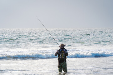 man fishing on the beach alone