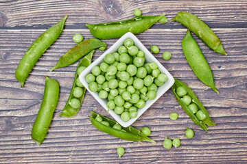 Chicharos frescos (leguminosas). Granos verdes frescos en recipiente blanco.