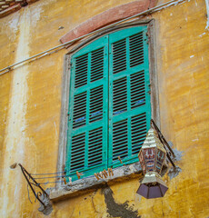 Fototapeta na wymiar An old window with a laundry and a Ramadan lantern in Egypt