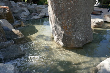 Stone column in center of shallow water pool