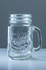 An empty jar with a grey background