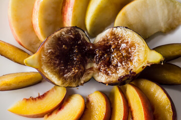 A honeyed fig surrounded by nice fresh fruits, seen from above
