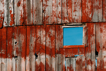 Fading red paint on the side of an old barn.