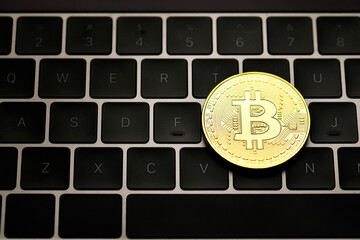 Golden cryptocurrency coin on computer keyboard. Idea for new type of money in the economy of the business world