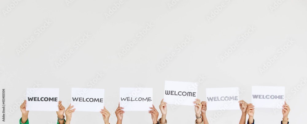 Wall mural studio shot of variety fonts welcome letters paper sign holding by unidentified unrecognizable facel