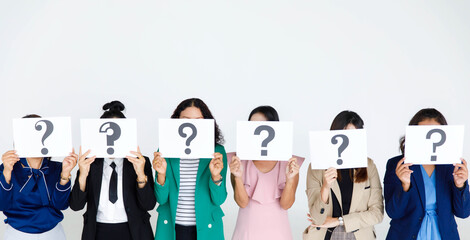 Studio shot of unrecognizable faceless female staff officer in business wears stand hold variety fonts of big question mark paper sign cover face thinking for answers on white background